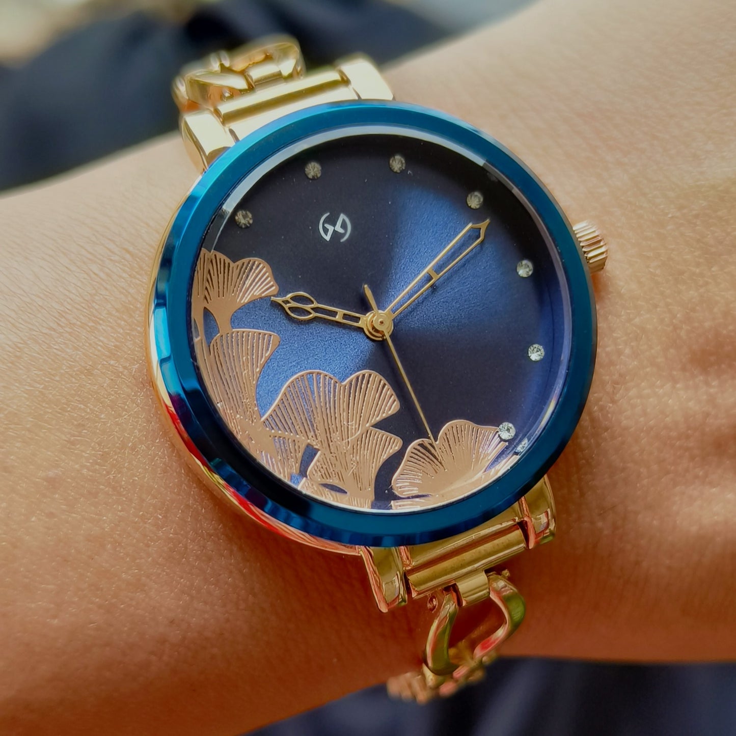 Super feminine rose gold bangle watch with blue dial and sleek chain with blue rim on the case