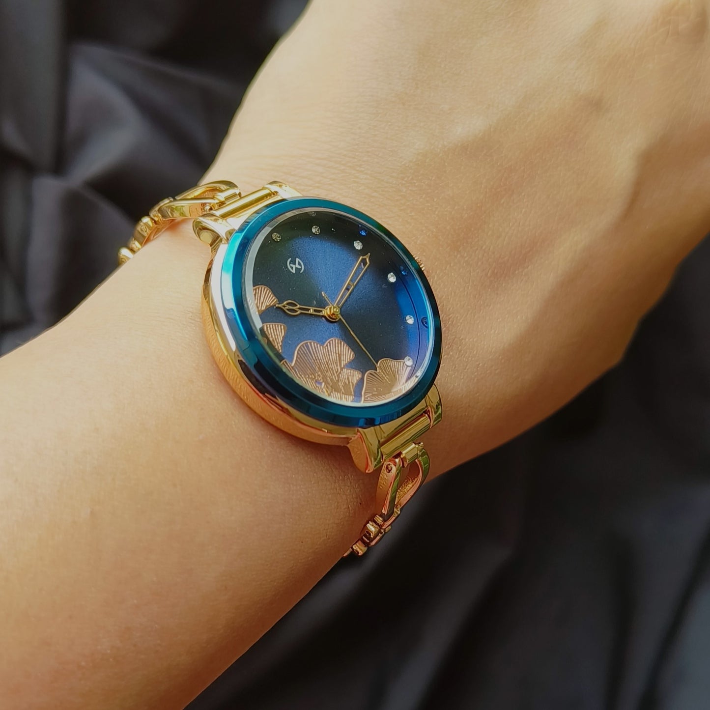 Super feminine rose gold bangle watch with blue dial and sleek chain with blue rim on the case